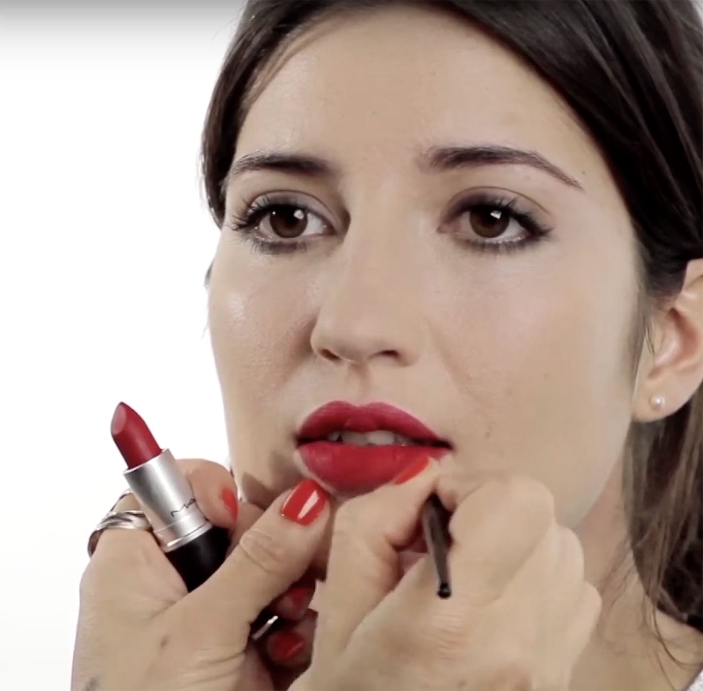 The face of a girl, being made up with deep red lipstick, by makeup artist Louise Wittlich