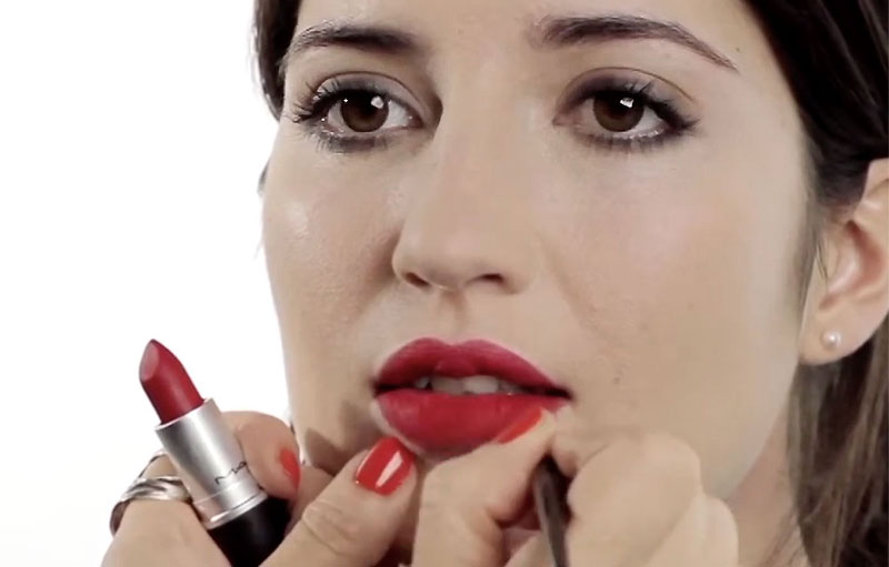 Un modèle, portant un rouge à lèvres rouge velours, en train d'être maquillée par Louise Wittlich, maquilleuse professionnelle et coach beauté.
