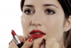 Un modèle en train de se faire maquiller la bouche en rouge profond par Louise Wittlich
